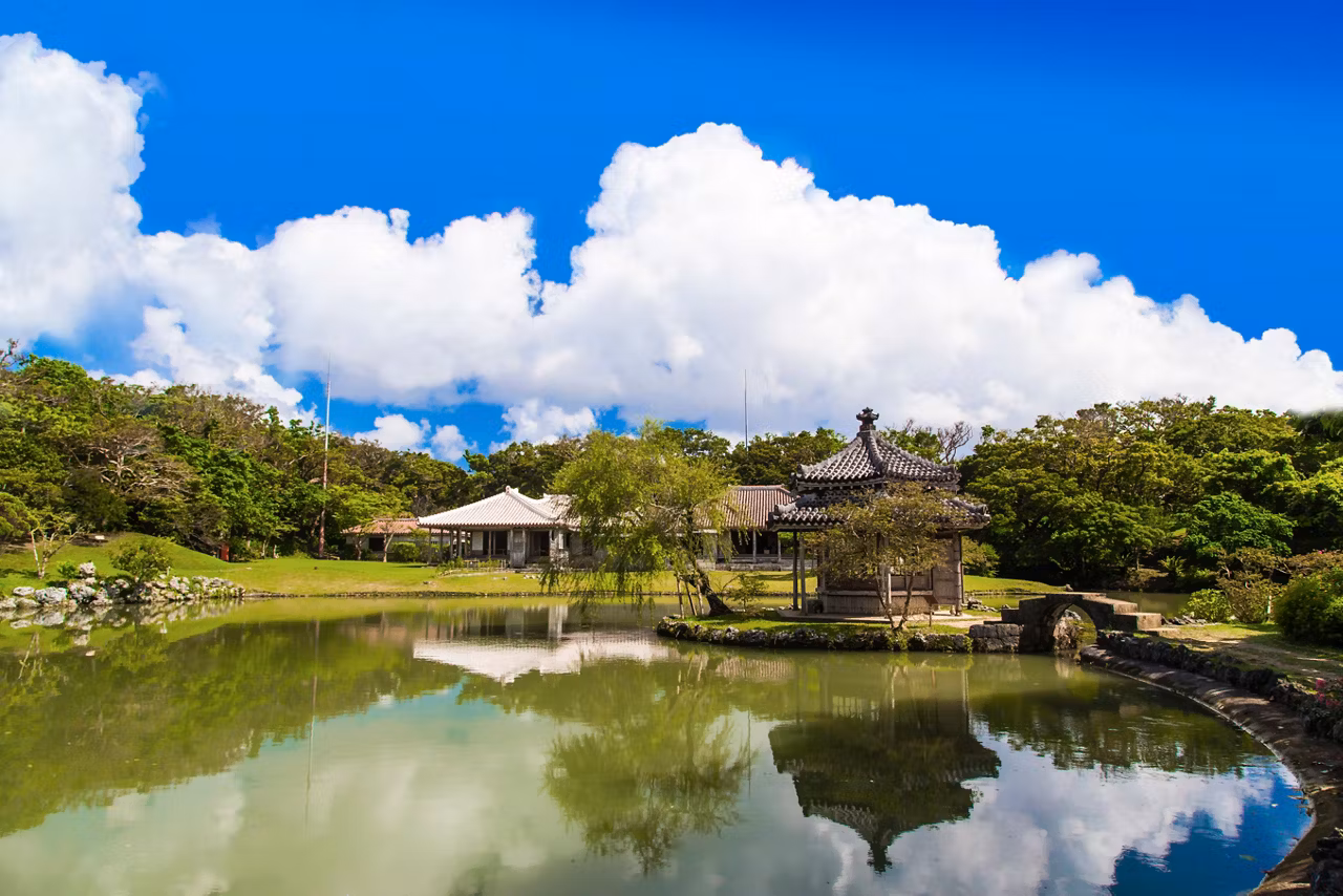 Un jardin serein à Naha, Japon, avec une végétation luxuriante et un étang paisible sous un ciel bleu clair | MSC Croisières