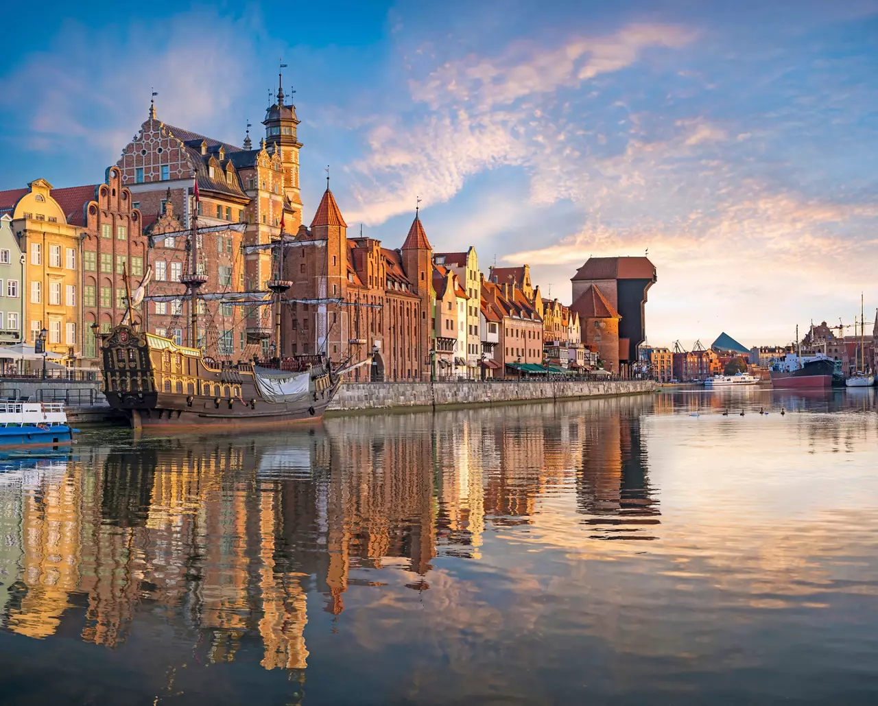 Historic buildings reflecting on the river in Gdansk during a serene summer evening | MSC Cruises