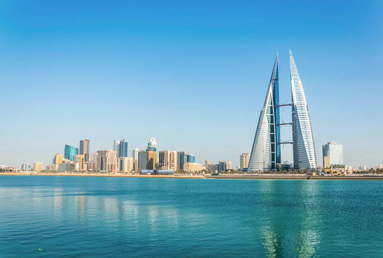 A panoramic view of Manama's skyline with modern skyscrapers against a clear blue sky and serene sea | MSC Cruises